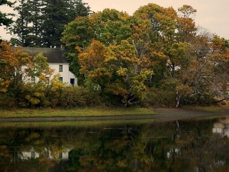 The historic Craigflower Schoolhouse among autumn trees on the Gorge Waterway, by the Craigflower Bridge into View Royal