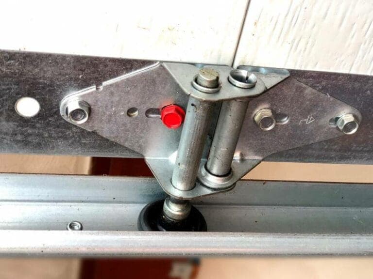 A garage door roller and hinge on the track, the kind of hardware checked on a tune-up