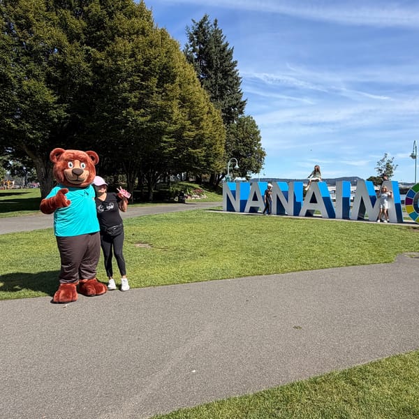 The Tedford bear mascot posing with a local fan near the Nanaimo letters sign
