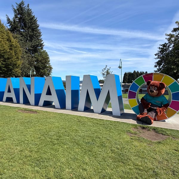 The Tedford bear mascot sitting beside the big Nanaimo letters sign