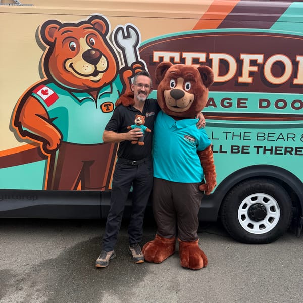 A Tedford team member and the bear mascot in front of a Tedford service van