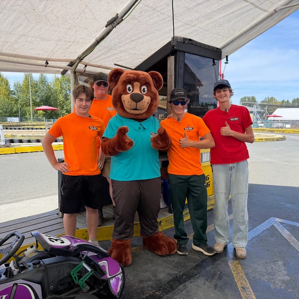 The Tedford bear mascot with the go-kart track crew