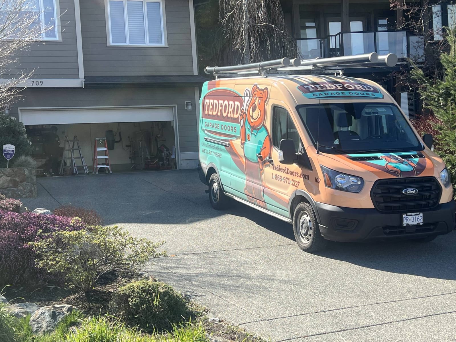 Tedford Garage Doors service van parked in a homeowner's driveway during a garage door call